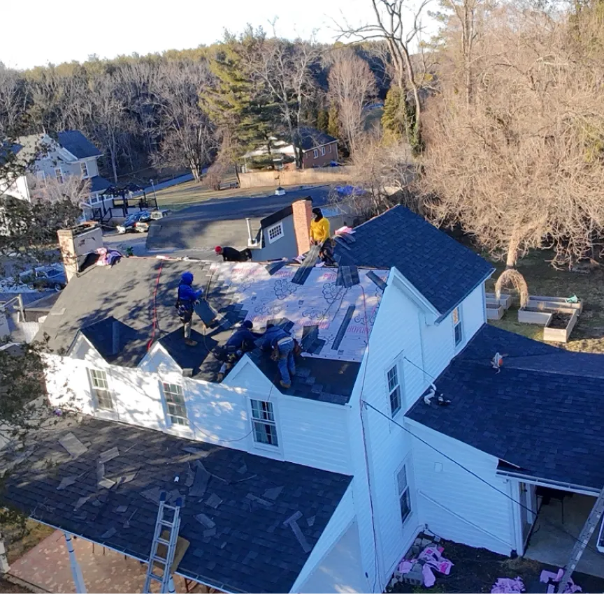 Workers installing shingle roofing on damaged roof in Tyson, VA